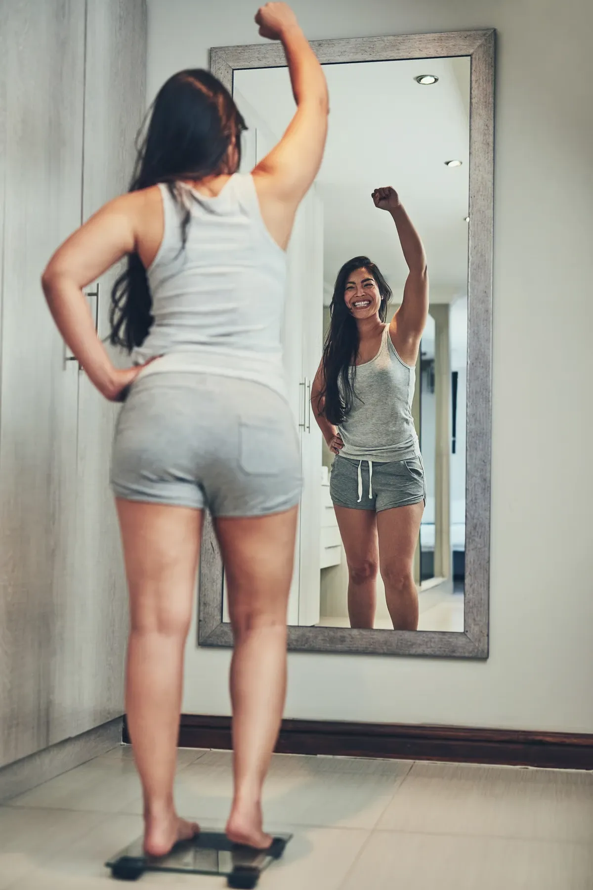 A woman celebrating her progress in the mirror