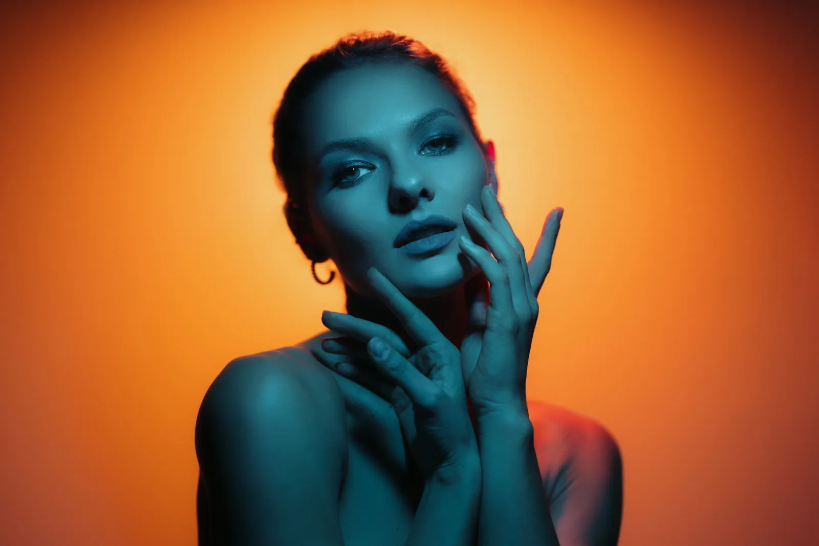A woman with glowing skin, hands framing her face