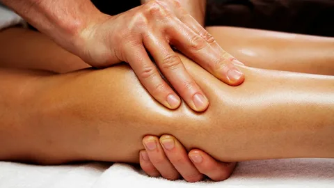 Therapist performing a lymphatic massage on a client's leg
